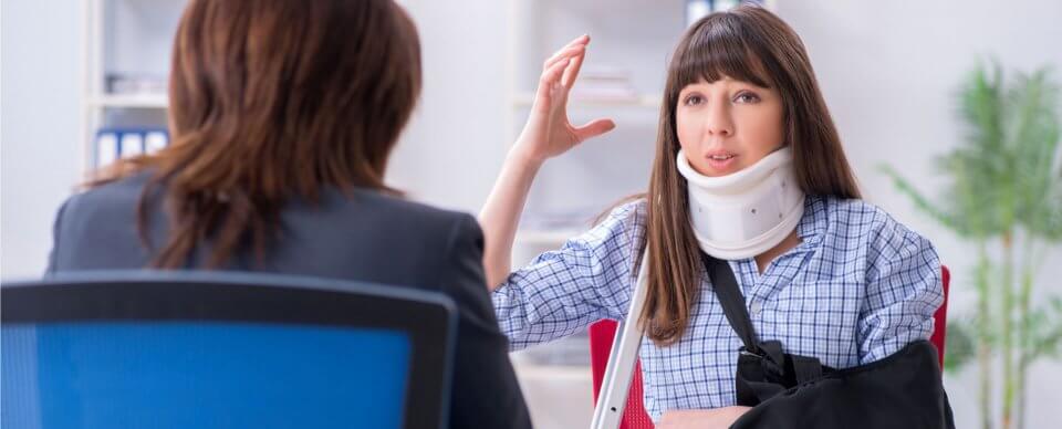 A woman in a cervical collar and braces explaining to her lawyer what happened during an accident to illustrate how to find good attorneys after an automobile accident
