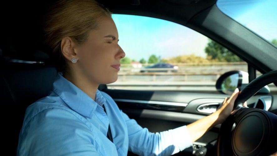 Woman behind the wheel closing her eyes, drowsy from medications.