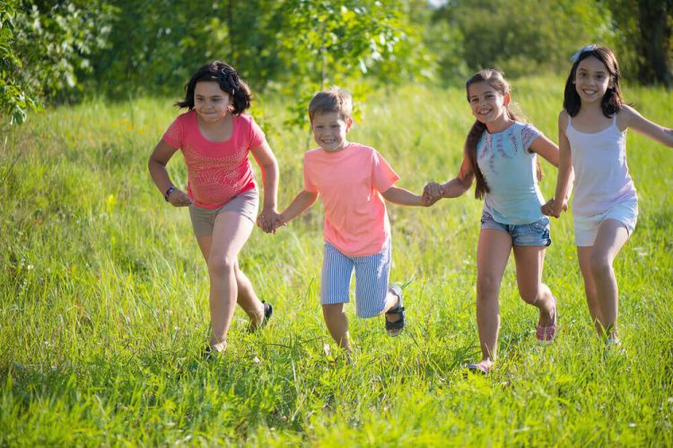 Group of happy children playing at summer camp to illustrate tips for kids at summer camp