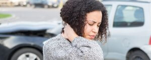 A young African-American woman having a headache because she doesn't know how does no-fault insurance work.