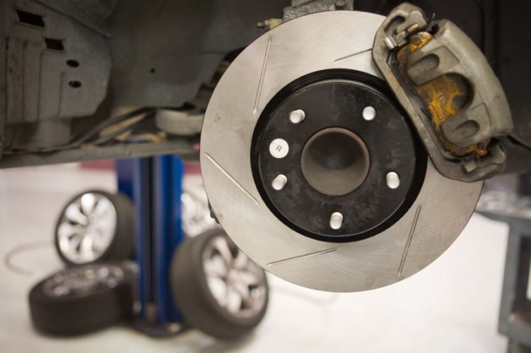 Close up to a well done brake job with wheels, calipers and other components in the background.