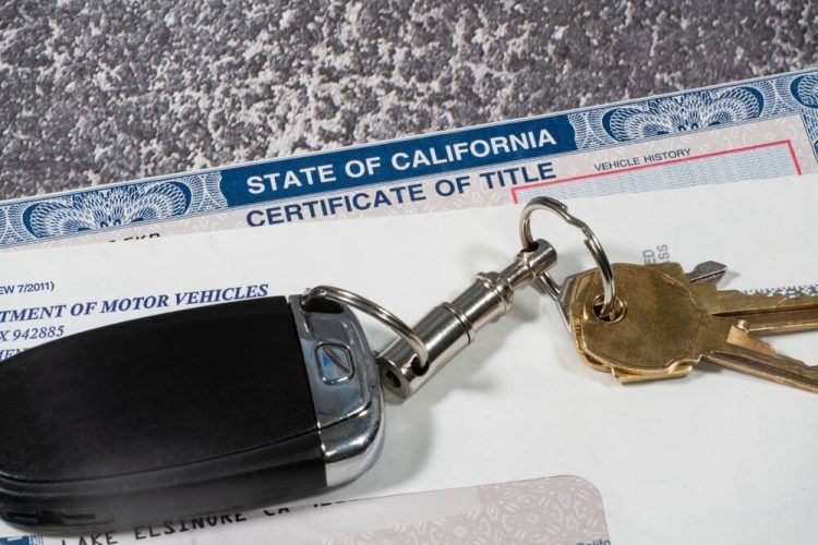 Close up of California automobile certificate of title in an envelope with keys.