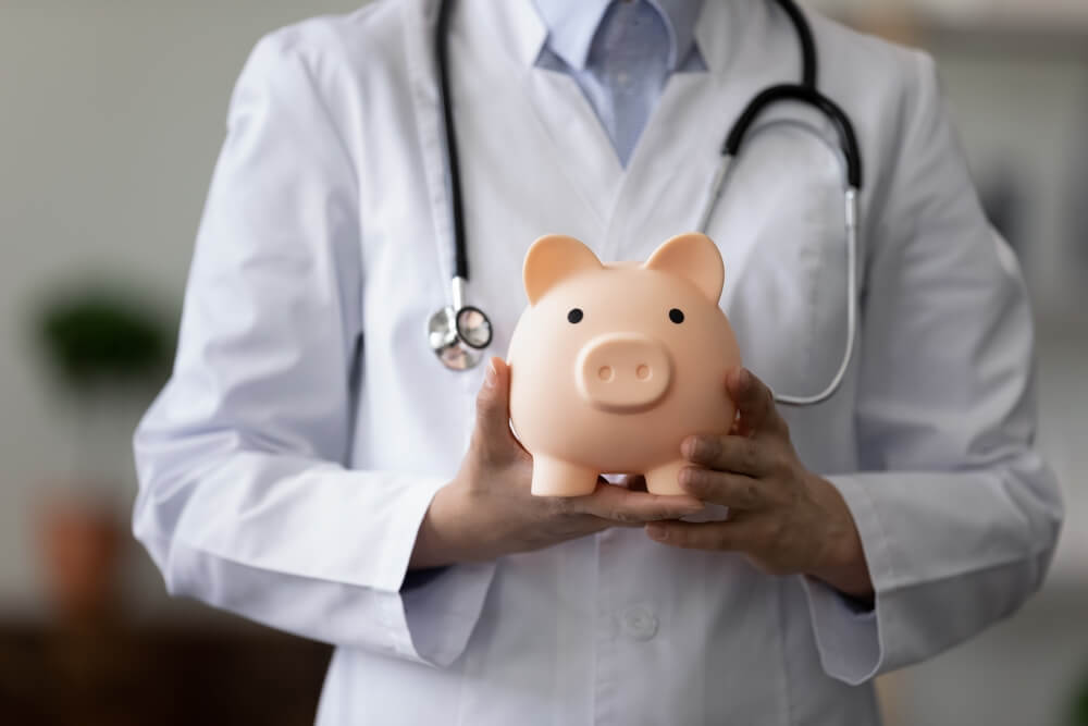 Doctor with a piggy bank in her hands