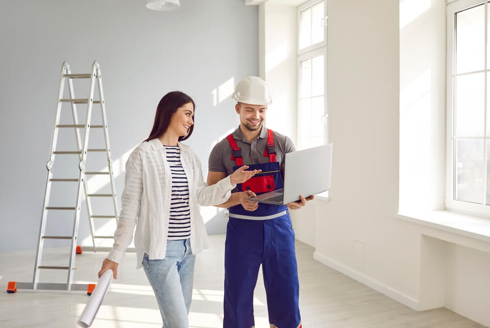 A woman looking at the home renovations she will make on the laptop while talking to an architect, before considering how that will affect her homeowners insurance.
