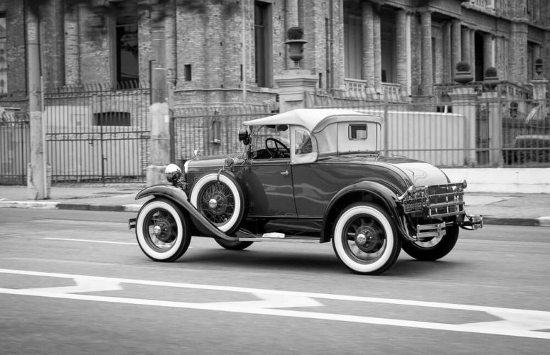 Vintage vehicle driving down the street - cheap car insurance.