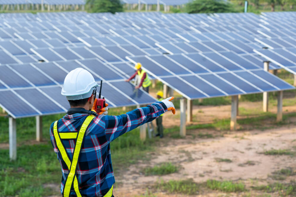 Man directs workers installing solar panels - affordable health coverage for independent contractors in California.