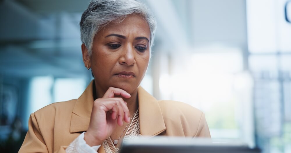 Older woman examines her home insurance policy - cheap homeowners insurance.